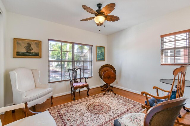 living area featuring hardwood / wood-style flooring, a wealth of natural light, and ceiling fan