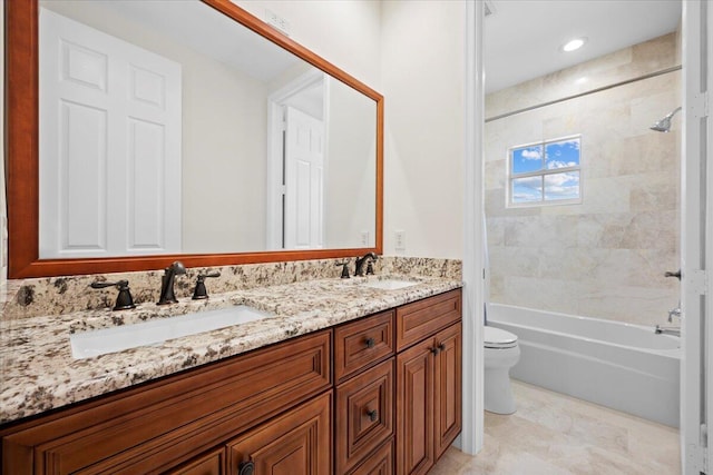 full bathroom featuring tiled shower / bath combo, vanity, and toilet