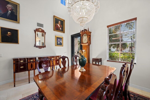 tiled dining space with a towering ceiling and a notable chandelier