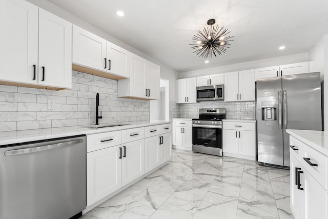 kitchen featuring white cabinetry, sink, backsplash, stainless steel appliances, and light stone countertops