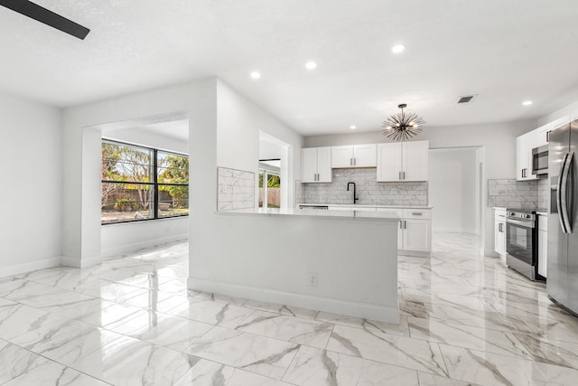 kitchen featuring tasteful backsplash, a textured ceiling, stainless steel appliances, and white cabinets