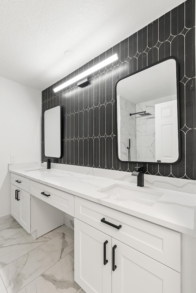 bathroom with vanity, a textured ceiling, and a shower