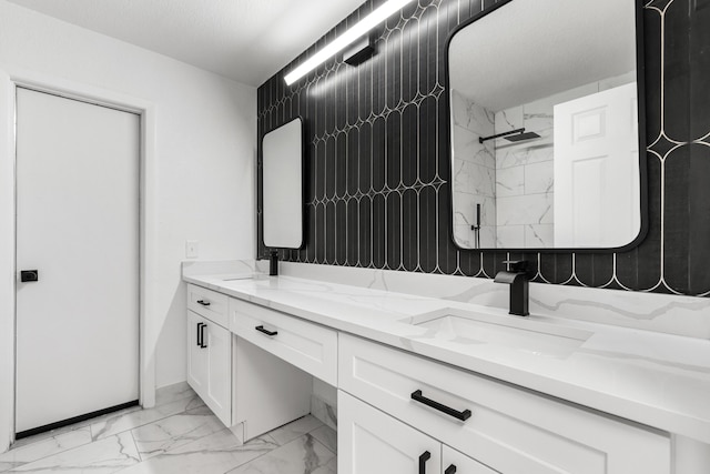 bathroom with tiled shower, vanity, and a textured ceiling