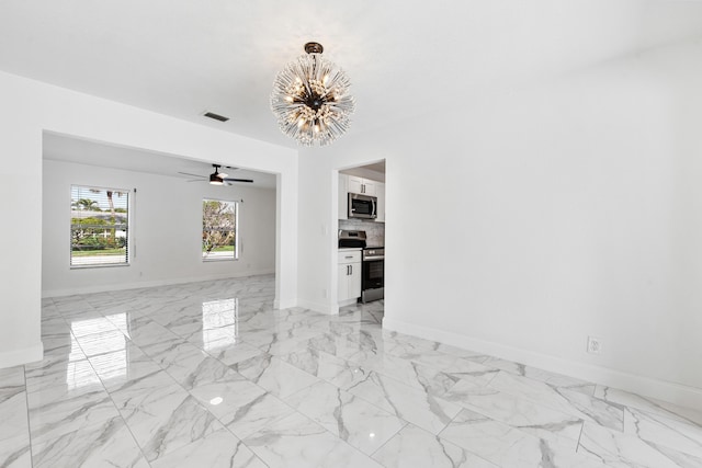 unfurnished room featuring ceiling fan with notable chandelier