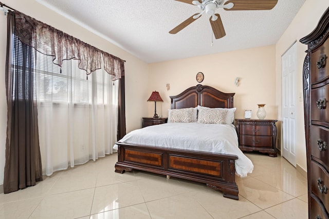 tiled bedroom featuring ceiling fan and a textured ceiling