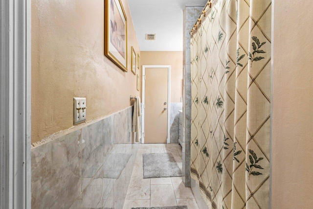 bathroom featuring tile walls and walk in shower