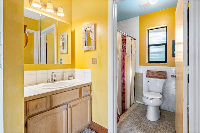 bathroom featuring vanity, tile walls, tile patterned floors, and toilet