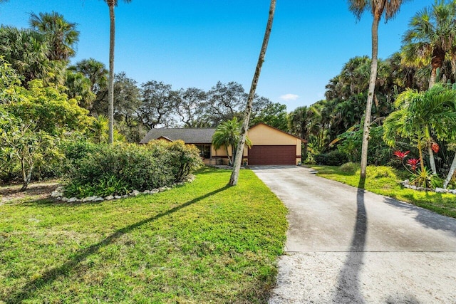 single story home featuring a garage and a front yard