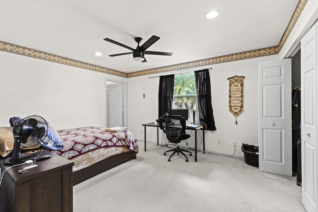 carpeted bedroom with ceiling fan and a textured ceiling