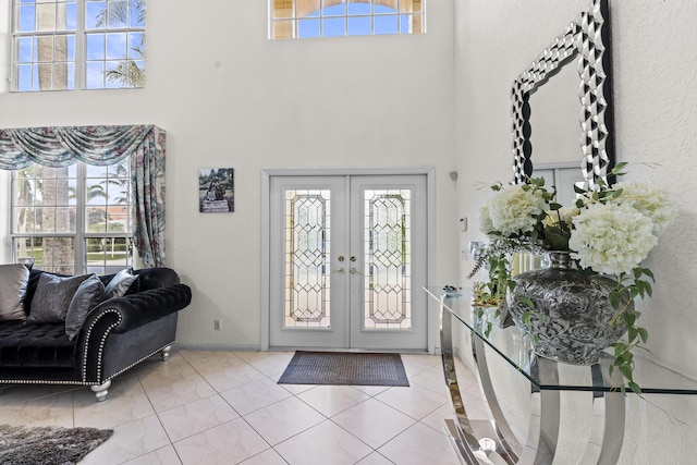 tiled entryway with french doors and a high ceiling