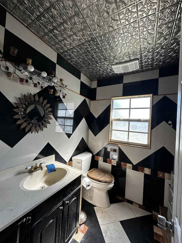 bathroom with tile walls, toilet, visible vents, and an ornate ceiling