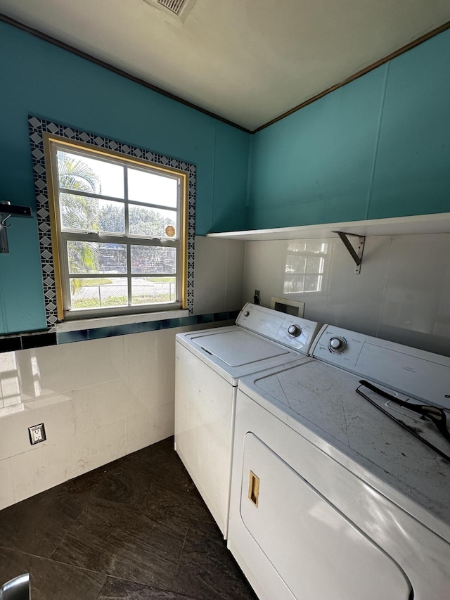 clothes washing area featuring washing machine and clothes dryer and laundry area