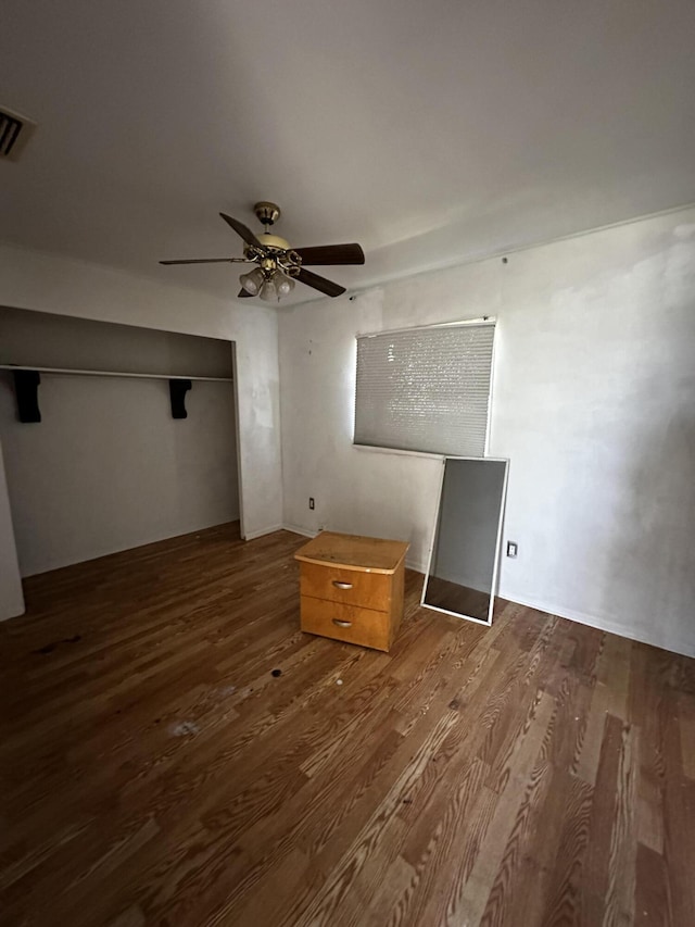 unfurnished bedroom featuring wood finished floors, visible vents, a closet, and ceiling fan