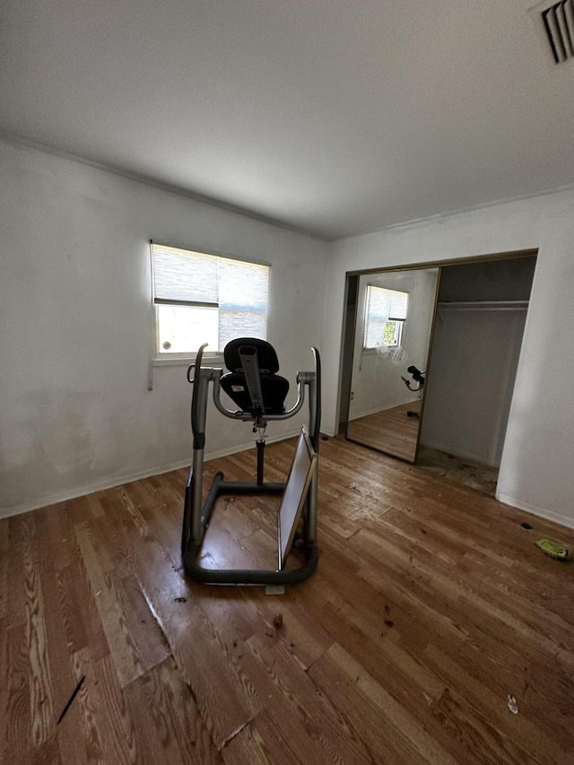 exercise area featuring a wealth of natural light, visible vents, and wood finished floors