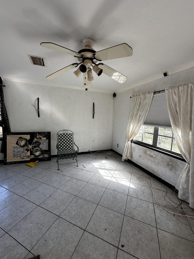 interior space with crown molding, a ceiling fan, and visible vents