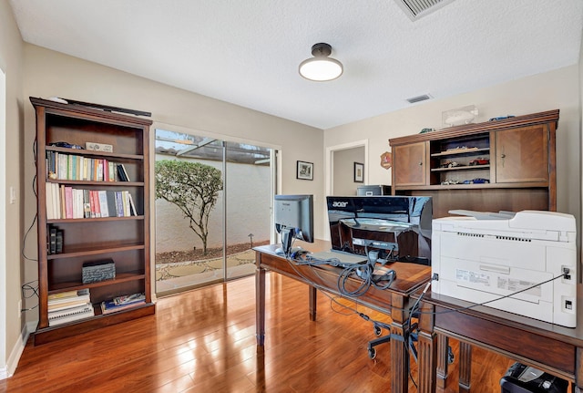 office with hardwood / wood-style flooring and a textured ceiling