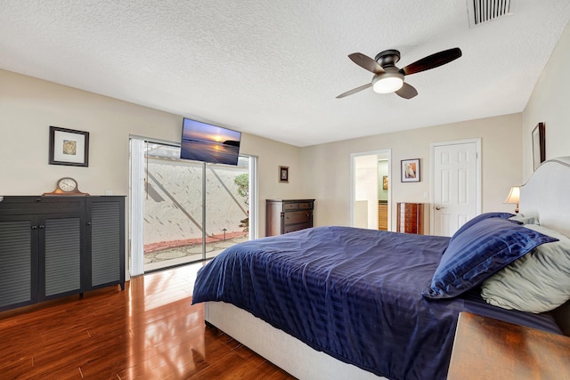 bedroom with dark hardwood / wood-style flooring, access to exterior, a textured ceiling, and ceiling fan