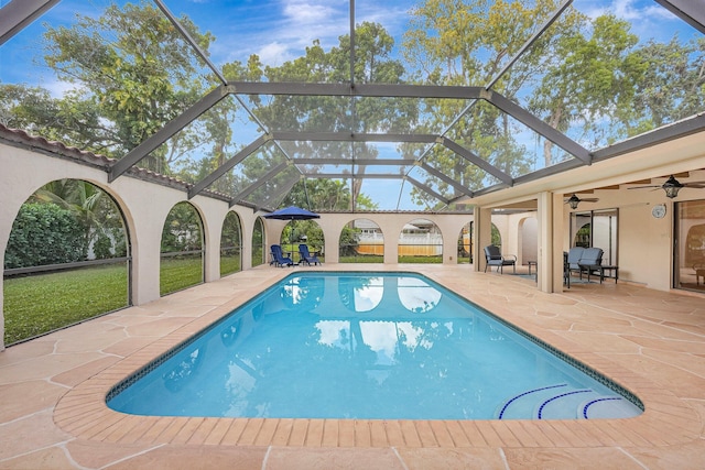 view of pool with a patio, a lanai, and ceiling fan