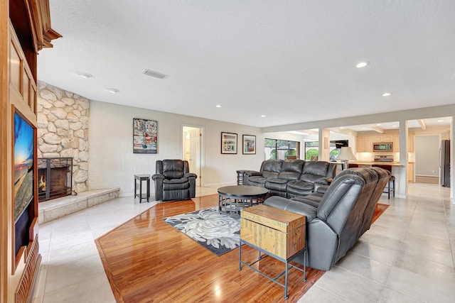 tiled living room with a fireplace and a textured ceiling