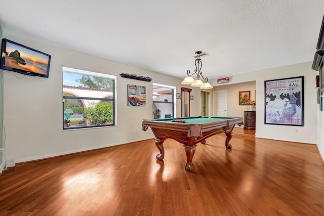 game room with hardwood / wood-style flooring, pool table, and a textured ceiling