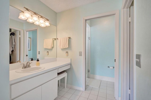 bathroom with tile patterned floors, vanity, and a textured ceiling