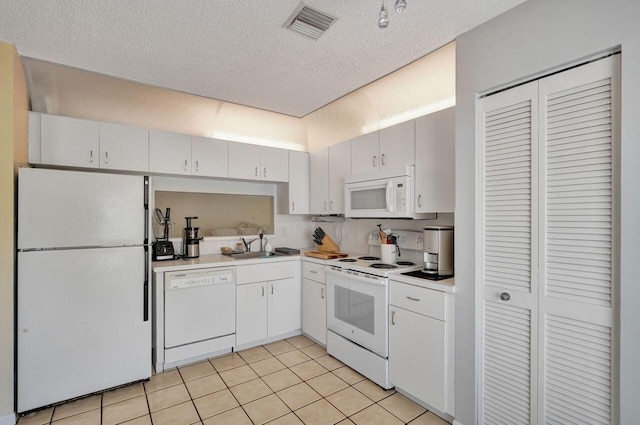 kitchen featuring light tile patterned flooring, sink, white cabinets, white appliances, and a textured ceiling