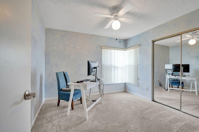 carpeted office with a textured ceiling and ceiling fan