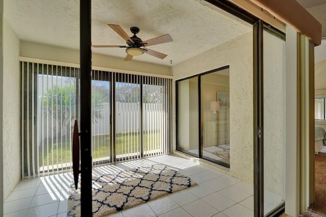 unfurnished sunroom with ceiling fan