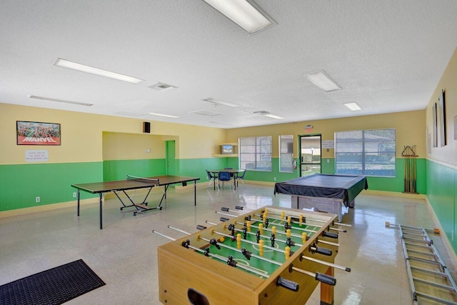 game room featuring plenty of natural light and a textured ceiling