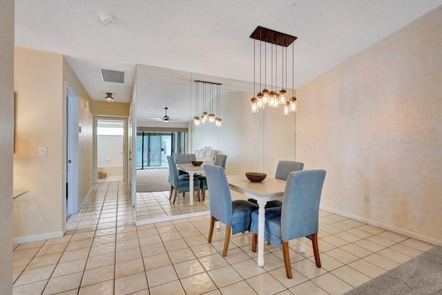 dining area with light tile patterned floors and a textured ceiling