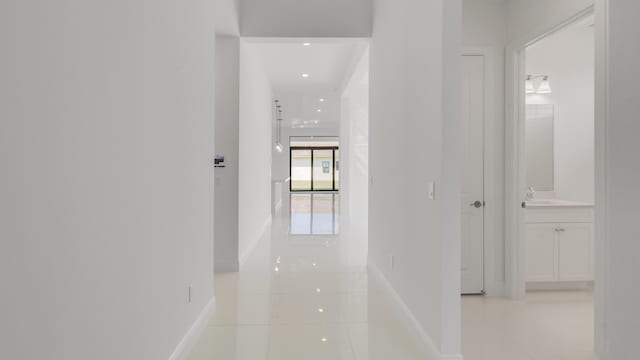 hallway featuring sink and light tile patterned floors