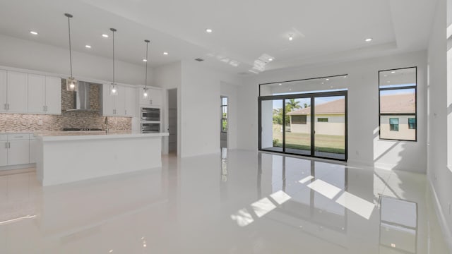 unfurnished living room with a tray ceiling and a towering ceiling