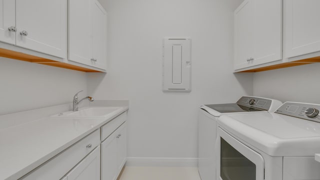 washroom featuring cabinets, washing machine and dryer, sink, and electric panel