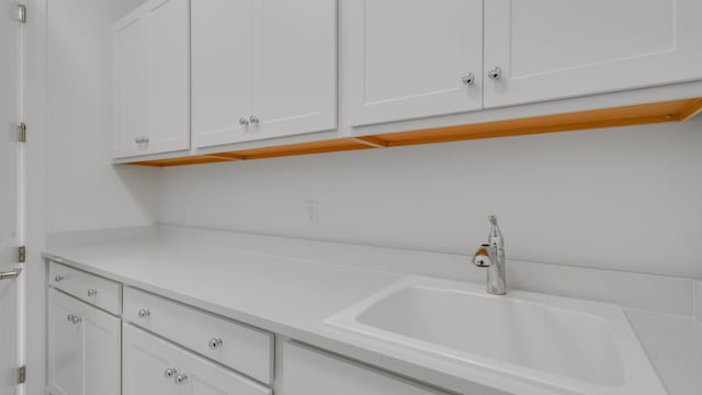 kitchen featuring white cabinetry and sink