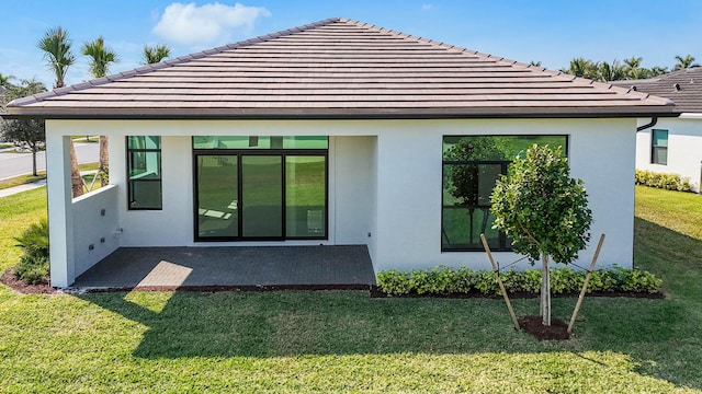 rear view of house featuring a yard and a patio