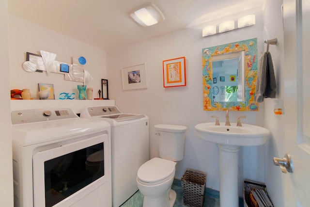 bathroom featuring sink, toilet, and washing machine and dryer