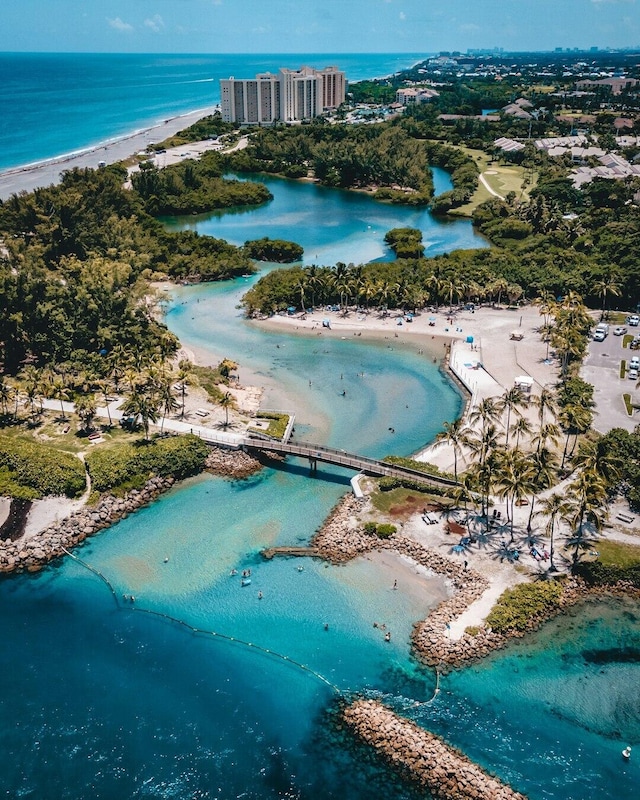 birds eye view of property featuring a water view and a beach view