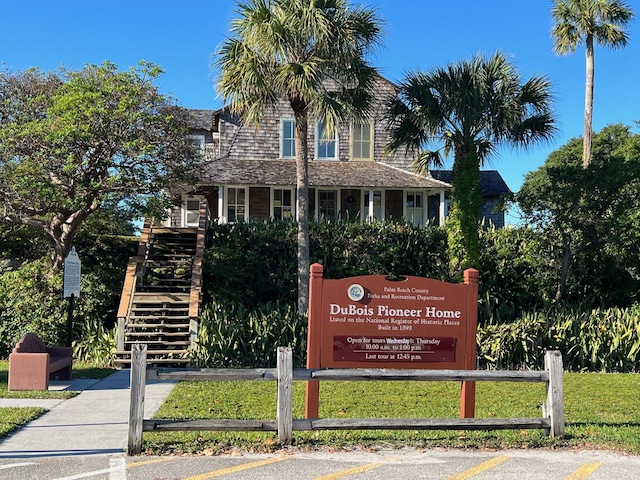 community sign featuring fence and uncovered parking