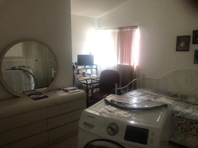 bedroom with washer / clothes dryer and vaulted ceiling