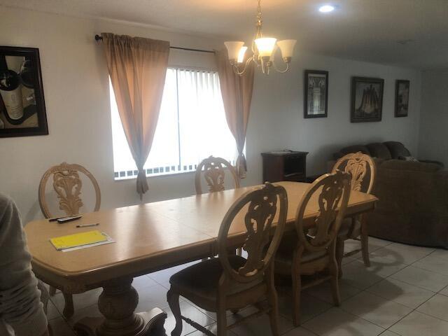 dining area featuring light tile patterned flooring and a chandelier