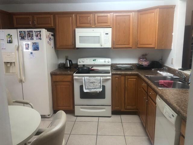 kitchen with white appliances, sink, and light tile patterned floors