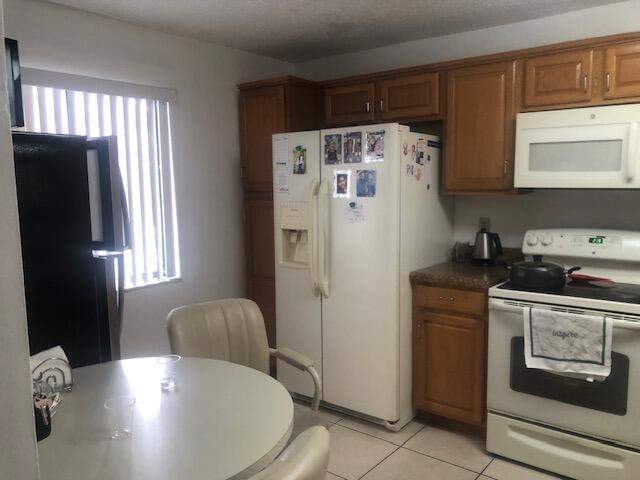 kitchen featuring white appliances and light tile patterned floors