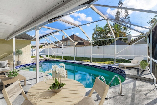 view of swimming pool featuring a patio area and glass enclosure