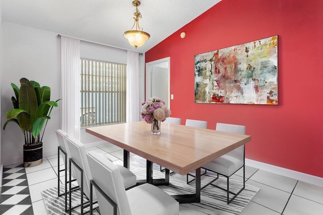 tiled dining space with lofted ceiling and a textured ceiling