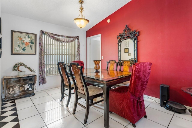 tiled dining area featuring lofted ceiling and a textured ceiling