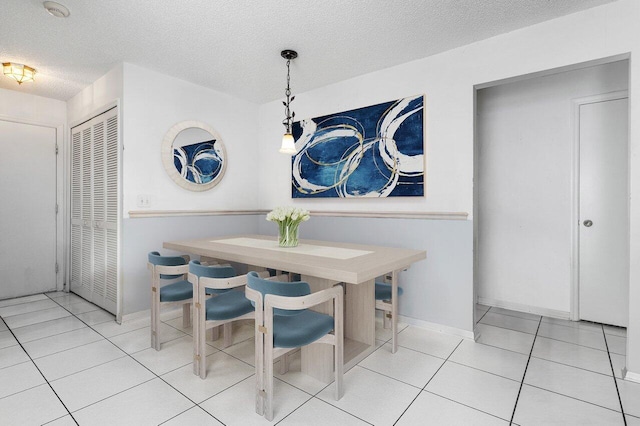 tiled dining space featuring a textured ceiling