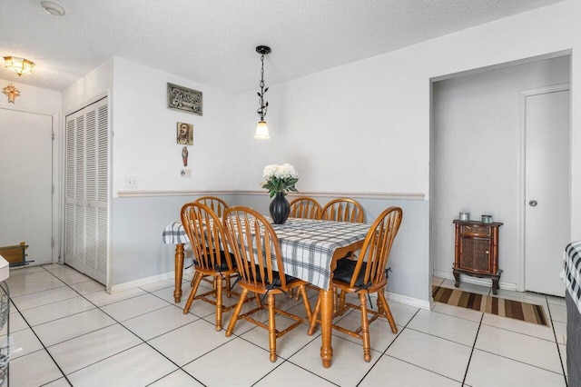 tiled dining space with a textured ceiling