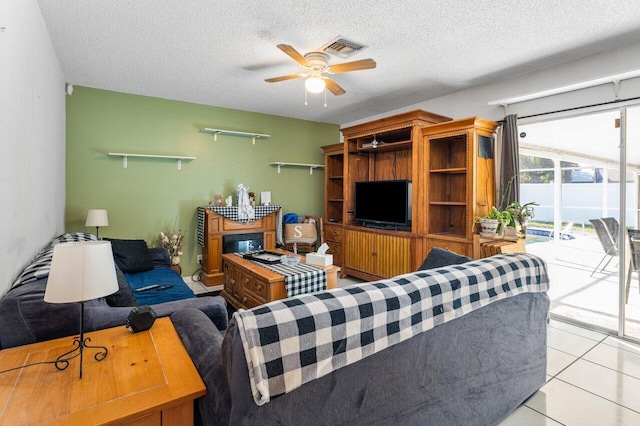 tiled living room with a textured ceiling and ceiling fan