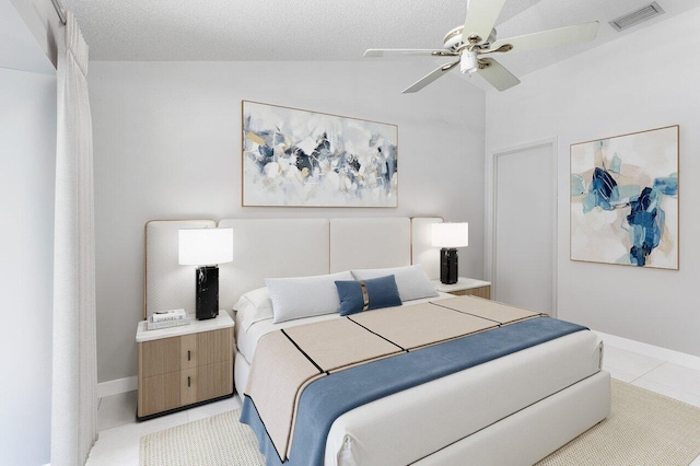 tiled bedroom featuring lofted ceiling, ceiling fan, and a textured ceiling