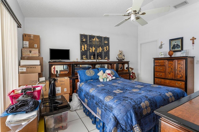 tiled bedroom featuring ceiling fan, vaulted ceiling, and a textured ceiling